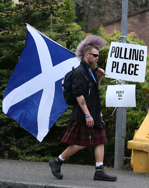 Chris McAleese holds a Saltire flag as he walks past Bannockburn polling station.
