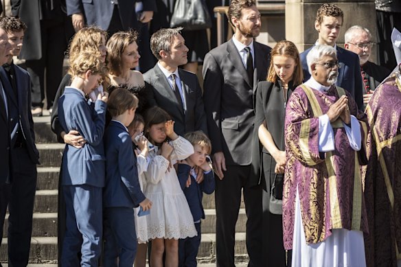 Family members embrace as the casket is carried onto the hearse.