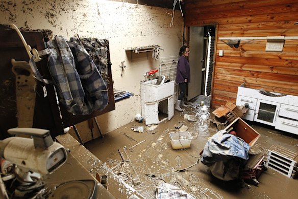 Patricia Whitehead gets her first look at the damage to the laundry of her Hooke Street home, Dungog. The waters reached to the ceiling and guttering, allowing them to step straight into an SES boat from the veranda when they were evacuated.
