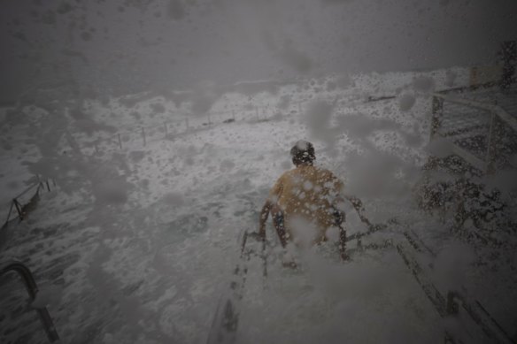 Wild weather at Bronte as a swimmer tries to enter the ocean pool.