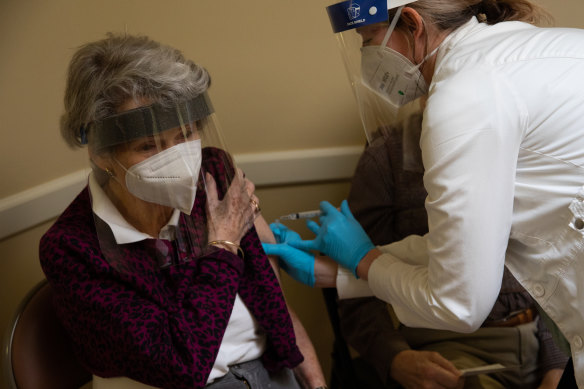 A healthcare worker administers the Pfizer-BioNTech vaccine to an aged care resident in Bloomfield Hills, Michigan, US.