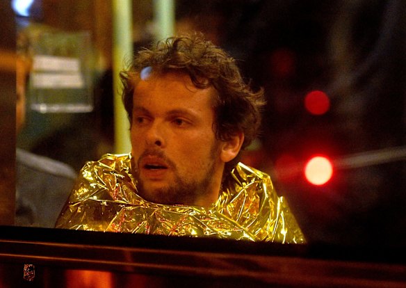 A survivor sits on a bus after escaping from the Bataclan concert hall.