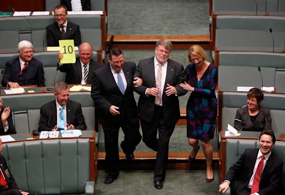 Harry Jenkins is dragged to the Speakers chair after being elected as Speaker of the House of Representatives as Independent MP Tony Windsor holds a scorecard of 10 aloft during the Opening of the 43rd Parliament of Australia at Parliament House Canberra