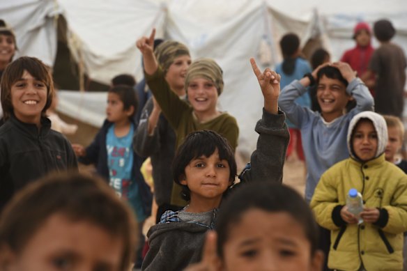 Children raise their index finger in the sign of the Islamic State in Al-Hawl camp in North East Syria. 