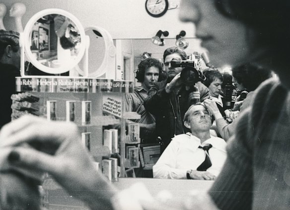Preparing for a TV debate the Labor opposition leader John Cain 'relaxes' in a makeup chair - surrounded by TV cameramen, sound recordists, photographers, reporters / journalists. 1982