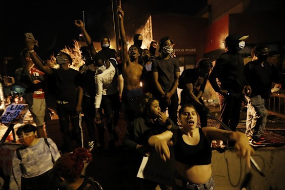 Protesters gather outside the burning Minneapolis police 3rd Precinct building.