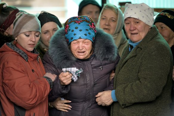 The mother of Russian Army soldier Rustam Zarifulin, who was killed fighting in Ukraine, cries surrounded by relatives during a farewell ceremony in his hometown of Kara-Balta, west of Bishkek, Kyrgyzstan.