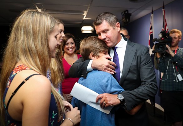 Premier Mike Baird embraces his family after a press conference announcing his resignation in Sydney. 