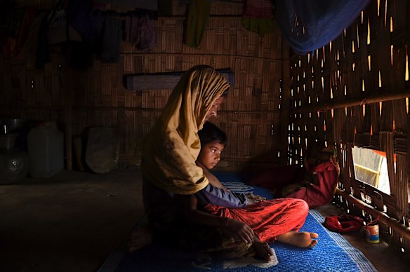 Subia Khatun 60 (left) holds her orphaned granddaughter Nuru Zannat aged 5 (right) in their shelter in the Kutupalong Camp.