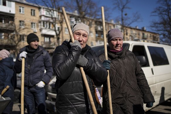 A woman cries before starting to clean the site where bombing damaged residential buildings in Kyiv, Ukraine. Russian forces pressed their assault on Ukrainian cities on Friday, with new missile strikes and shelling on the edges of the capital Kyiv and the western city of Lviv.