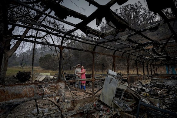 Mark and his daughter Kylee comfort each other in front of the remains of the property.