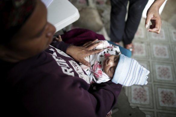 Malinda Ben with 2-month-old daughter Emmerylyn Ben who are waiting to get vaccinations at the Susu Mamas clinic in Mount Hagen. 
