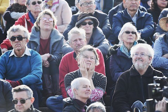Crowds on the Opera House forecourt watch the state memorial service for Bob Hawke on a big screen.