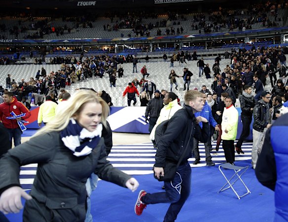 Hundreds of people spilled onto the field of the Stade de France stadium after explosions were heard nearby during a friendly match between the French and German national soccer teams.