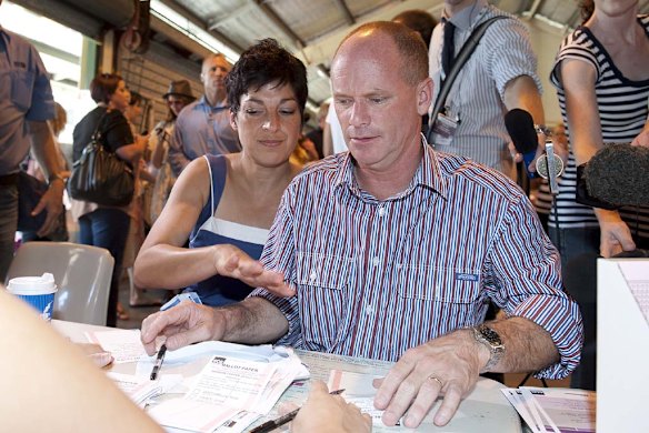 Campbell Newman and Lisa Newman get their voting slips at Newmarket State School. Photo: Harrison Saragossi