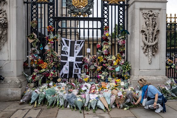  A woman lays flowers outside Buckingham Palace on September 9, 2022 in London.