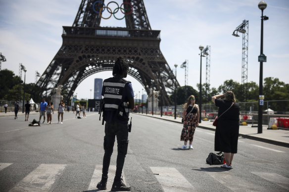 Police guard the Eiffel Tower ahead of the start of the Olympics.