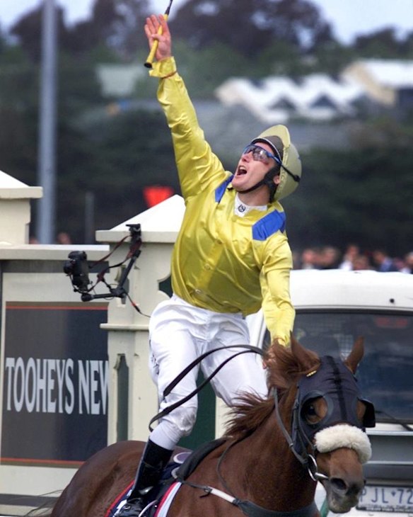 Damien Oliver salutes his recently deceased brother Jason, after winning the 2002 Melbourne Cup on Media Puzzle.