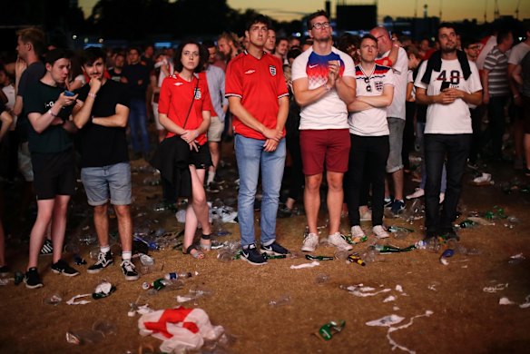 England soccer fans react after losing the semifinal match between Croatia and England at the 2018 soccer World Cup, in Hyde Park, London.