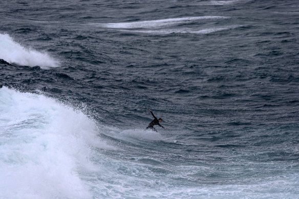 A surfer braves wild weather at Bondi beach as damaging southerly winds hit Sydney.