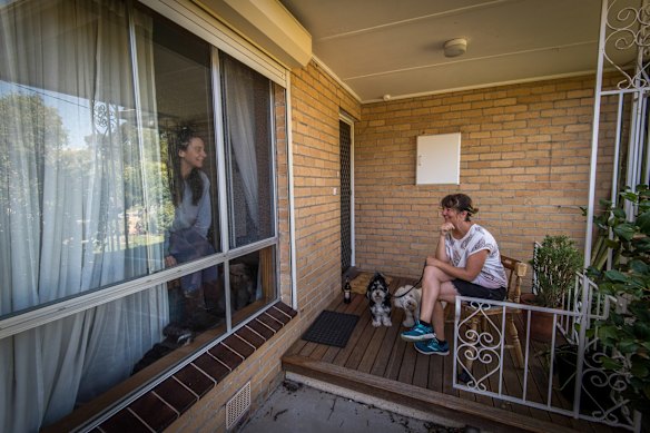 Miriam has a conversation with her friend Lana through the window of her home.