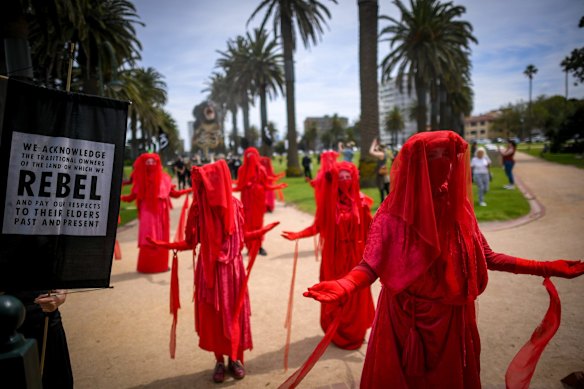 The sombre Extinction Rebellion procession through Catani Gardens was accompanied by a group of musicians playing Chopin’s Funeral March. The group’s signature, silent ‘Red Rebels’ - wearing flowing red dresses and white face paint - lead the protest of more than 100 people.