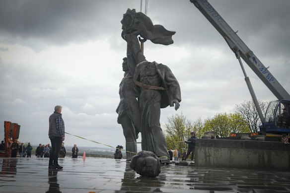 A Soviet era monument to a friendship between Ukrainian and Russian nations is seen during its demolition, amid Russia's invasion in central Kyiv.