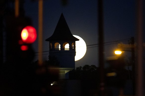 A full moon rises behind the Witch's Hat Water Tower in Tower Hill Park, Minneapolis.