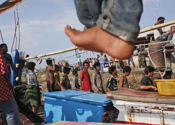 Rescued migrants disembark from an Acehnese fishing boat upon arrival in Simpang Tiga, Aceh province, Indonesia, Wednesday, May 20, 2015. Hundreds of migrants stranded at sea for months were rescued and taken to Indonesia, officials said Wednesday, the latest in a stream of Rohingya and Bangladeshi migrants to reach shore in a growing crisis confronting Southeast Asia. 
