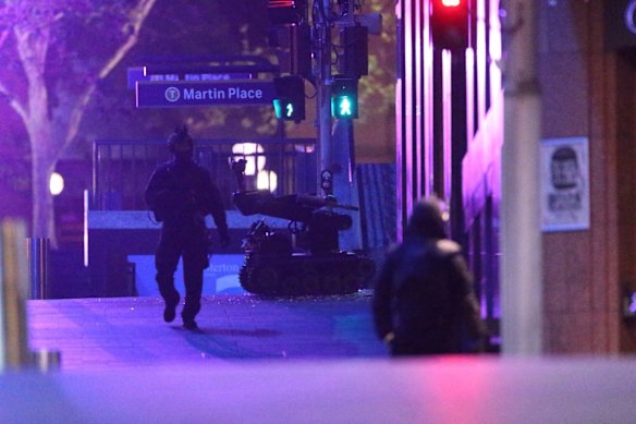 Police guide a robot into the Lindt Chocolat Cafe in Martin Place.