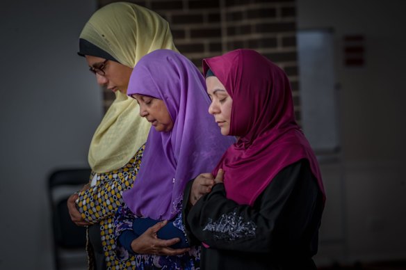 Muslim women Mai Shouman, Meherun Nisa and Rita Joyan pray at Gungahlin Mosque on Saturday afternoon, after terror attacks at mosques in New Zealand on Friday.