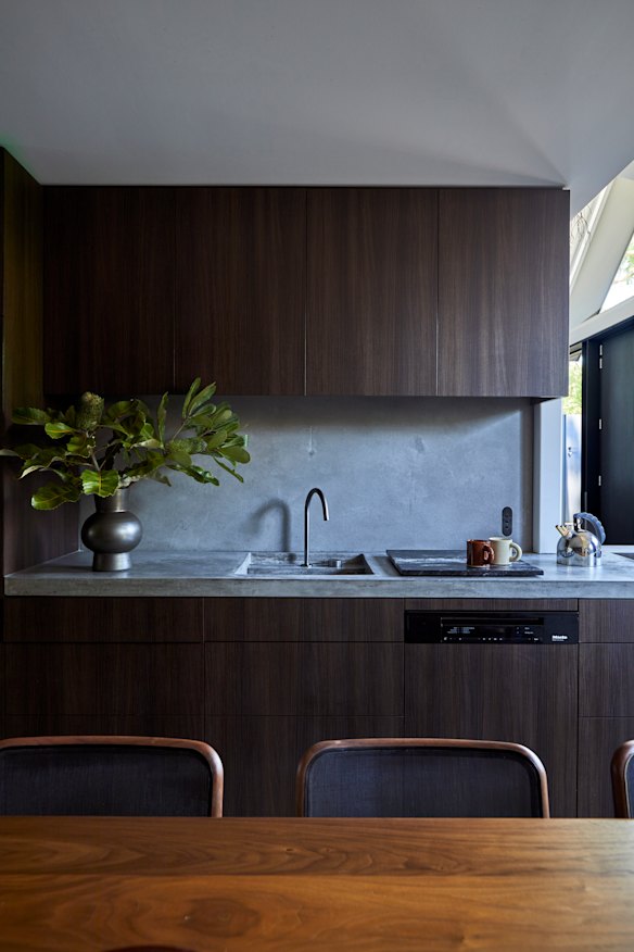 The kitchen cabinetry features oak veneers and a concrete benchtop. Designed by Those Architects and made by Mark Welch, the dining table is solid walnut.