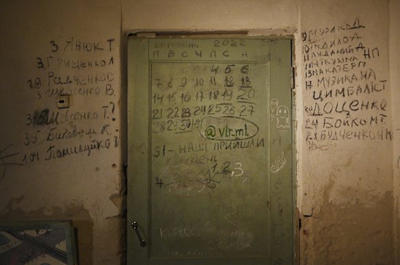 The back of a door in a basement room at the school in Yahidne shows a calendar of the 25 days 371 residents of the town were detained. On the left of the door is a list of names and dates of death of seven people shot by Russian soldiers, and on the right is a list of the 10 people who died due to conditions in the basement. 