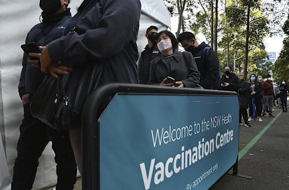 People queue on day two of the Sydney lockdown for COVID-19 vaccinations at the NSW Health Vaccination Centre at Olympic Park.