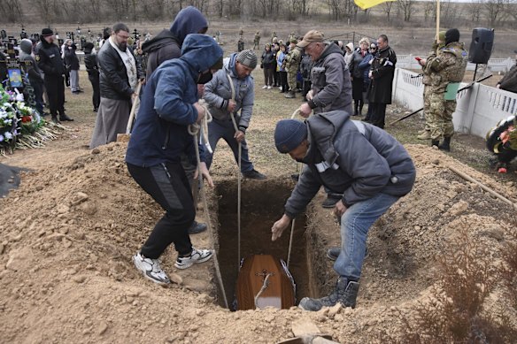 Men lower the coffin of Ukrainian serviceman Oleksiy Lunyov into his gravesite in Yuzhne, Odessa region, Ukraine. Lunyov was killed during a Russian missile attack in Mykolaiv on March 18.