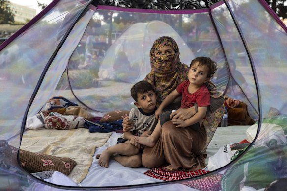 Farzia, 28, who lost her husband in Baghlan one week ago to fighting by the Taliban, sits with her children, Subhan, 5, and Ismael ,2, in a tent at a makeshift IDP camp in Share-e-Naw park on August 12, 2021 in Kabul, Afghanistan.
