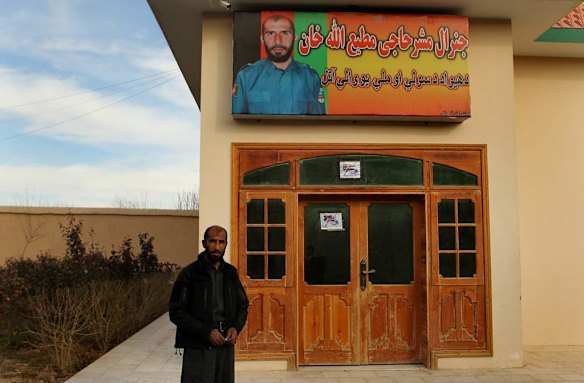 Uruzgan Police Chief, Matiullah Khan, stands infront of a large poster of himself mounted on the wall of one of the buildings inside his compound in Tarin Kowt, Uruzgan, Afghanistan.