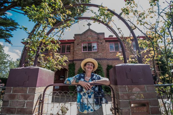 The owner of the former Saint Joseph's Convent in Bungendore, Pamela Orr, stands at its gates.