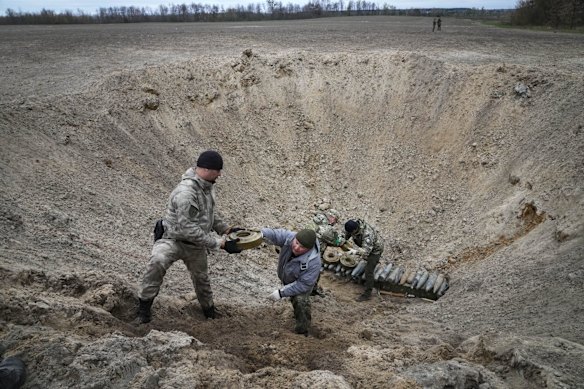 Interior ministry sappers pile explosives in a hole to detonate them near a mine field after recent battles at the village of Moshchun, close to Kyiv.