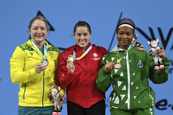 From left, Australia's Sarah Maureen Cochrane, Canada's Maude G Charron and Nigeria's Islamiyat Adebukola Yusuf pose on the podium with their medals after the Women's 64kg Final.