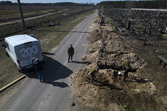 Cemetery workers dig a grave for Tetyana Gramushnyak, 75, who was killed during shelling while cooking food outside her home in Bucha.