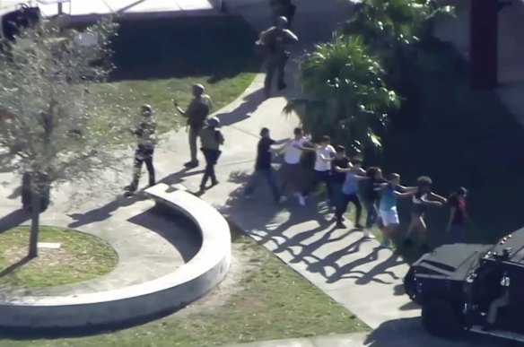 In this frame grab from video provided by WPLG-TV, students from the Marjory Stoneman Douglas High School in Parkland, Fla., evacuate the school following a shooting.