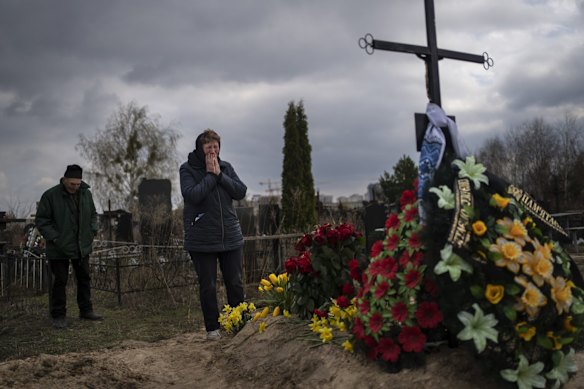 Galyna Bondar, mourns next to the grave of her son Oleksandr, 32, after burying him at the cemetery in Bucha, on the outskirts of Kyiv, Ukraine.