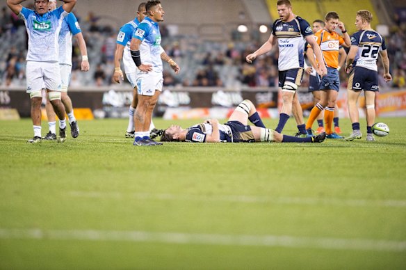 Brumbies skipper Sam Carter lies motionless after he knocked-on.