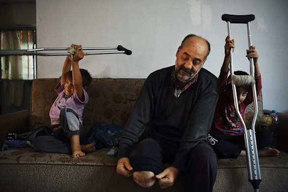 Wafa Gourani 47 a dessert chef from Aleppo (centre) at home with his two youngest sons Hamza Gourani, aged 6 years old (left) and Abdullah Gourani, aged 8 years old (right) in their rented family apartment in Istanbul. 