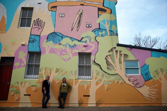 Street artist Birdhat (right) and Victoria and Hobbs cafe owner Dale with a recently completed mural. Marrickville Council is pairing street artists with homeowners to make giant murals on their walls and deter graffiti artists.