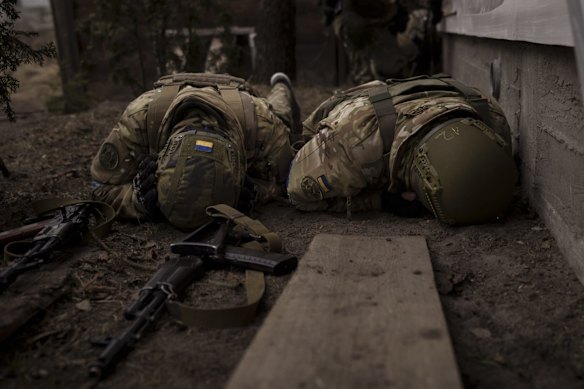Ukrainian soldiers take cover from incoming artillery fire in Irpin.