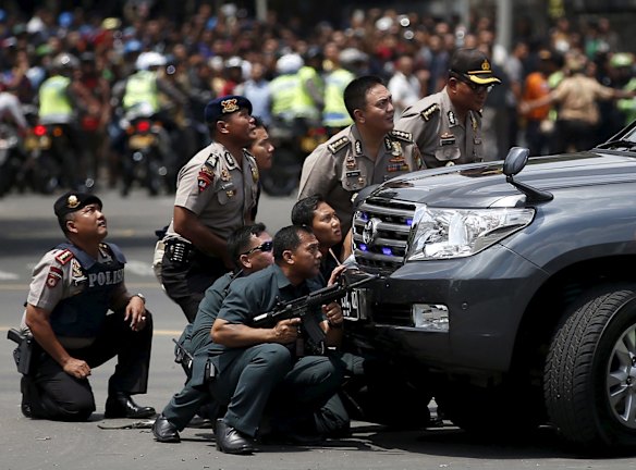 Police officers react near the site of a blast in Jakarta, Indonesia, January 14, 2016. Several explosions went off and gunfire broke out in the centre of the Indonesian capital on Thursday and police said they suspected a suicide bomber was responsible for at least one the blasts.   