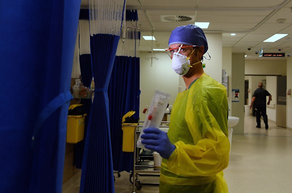 St Vincent's Hospital registered nurse Damien Davis Frank holds a testing swab for coronavirus.