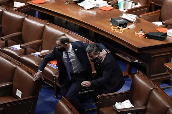 Lawmakers evacuate the floor as protesters try to break into the House Chamber.